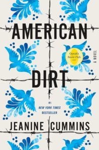 American Dirt by Jeanine Cummins book cover featuring blue and white ethnic titles. 